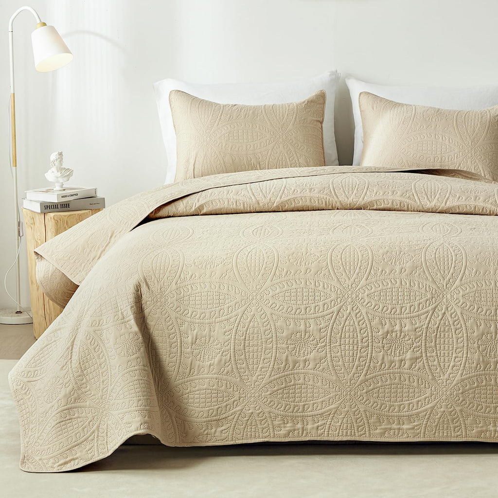 Beige embossed quilt set on bed