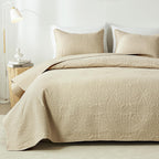 Beige embossed quilt set on bed