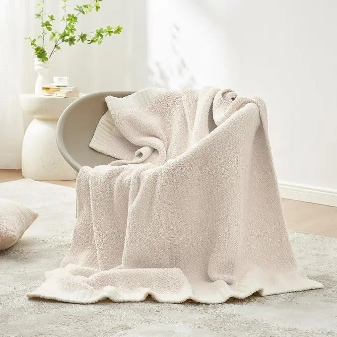 Beige reversible knit throw blanket on chair