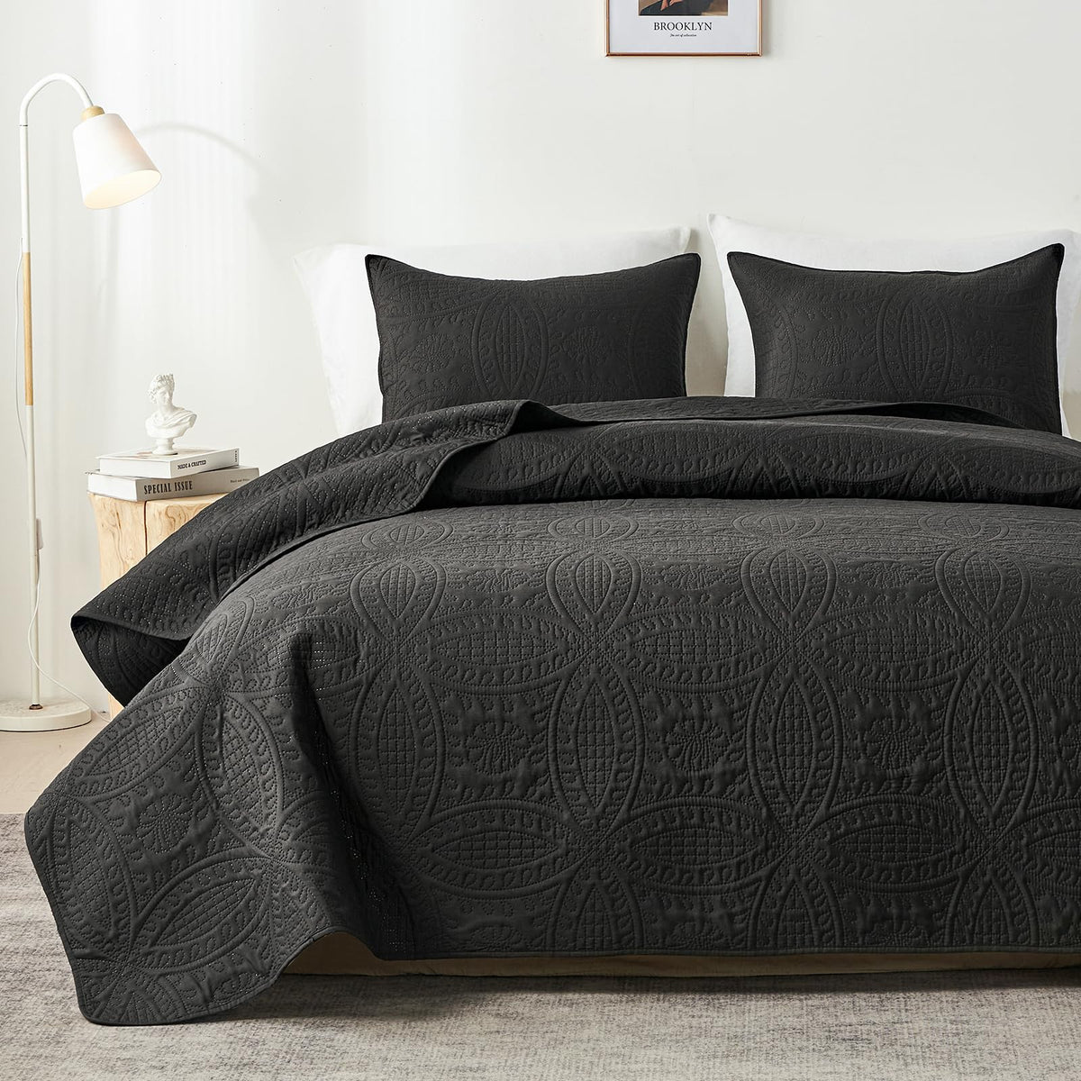 Black embossed quilt set on bed