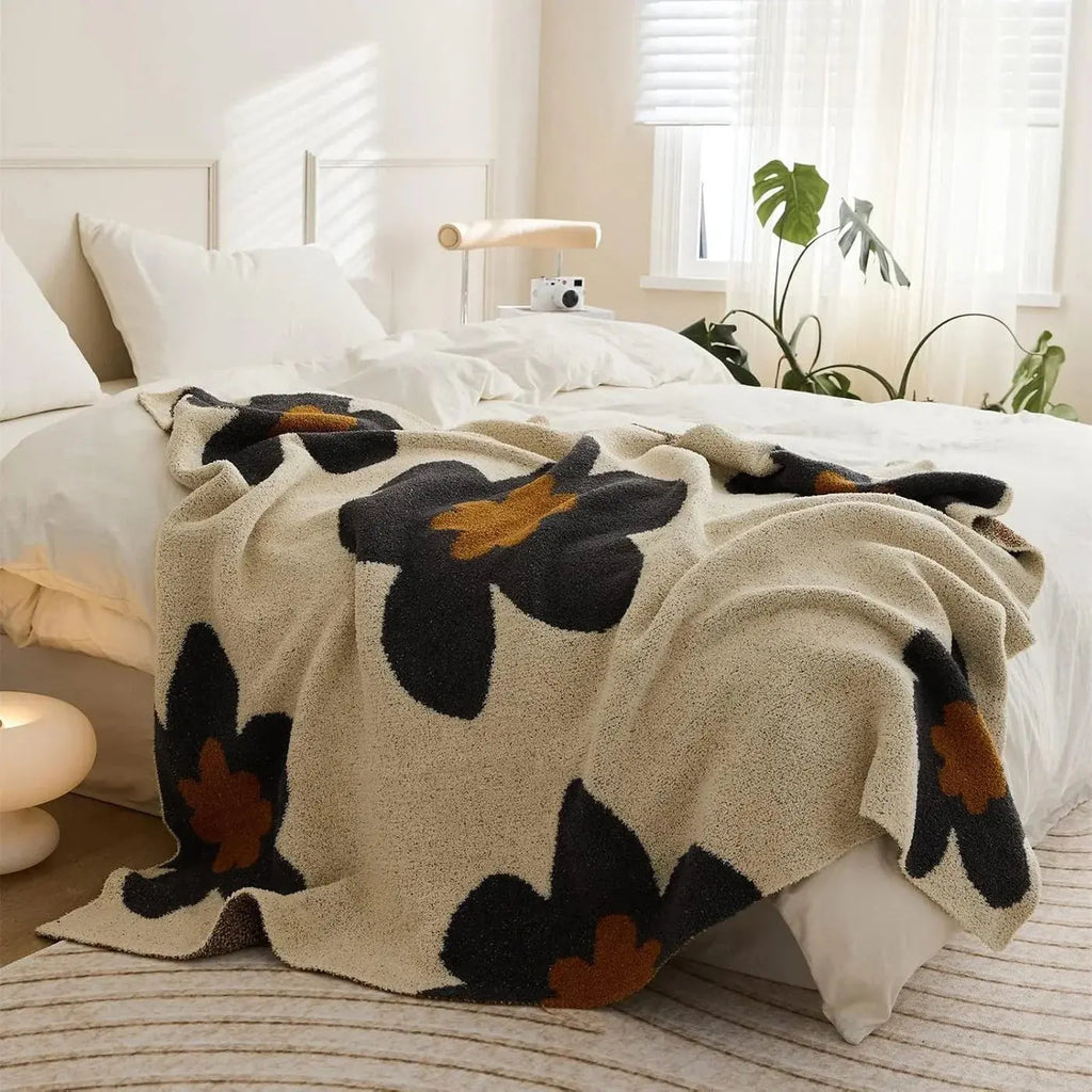 Black floral fleece throw on bed
