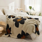 Black floral fleece throw on bed