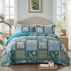 Blue and teal floral patchwork quilt set on bed