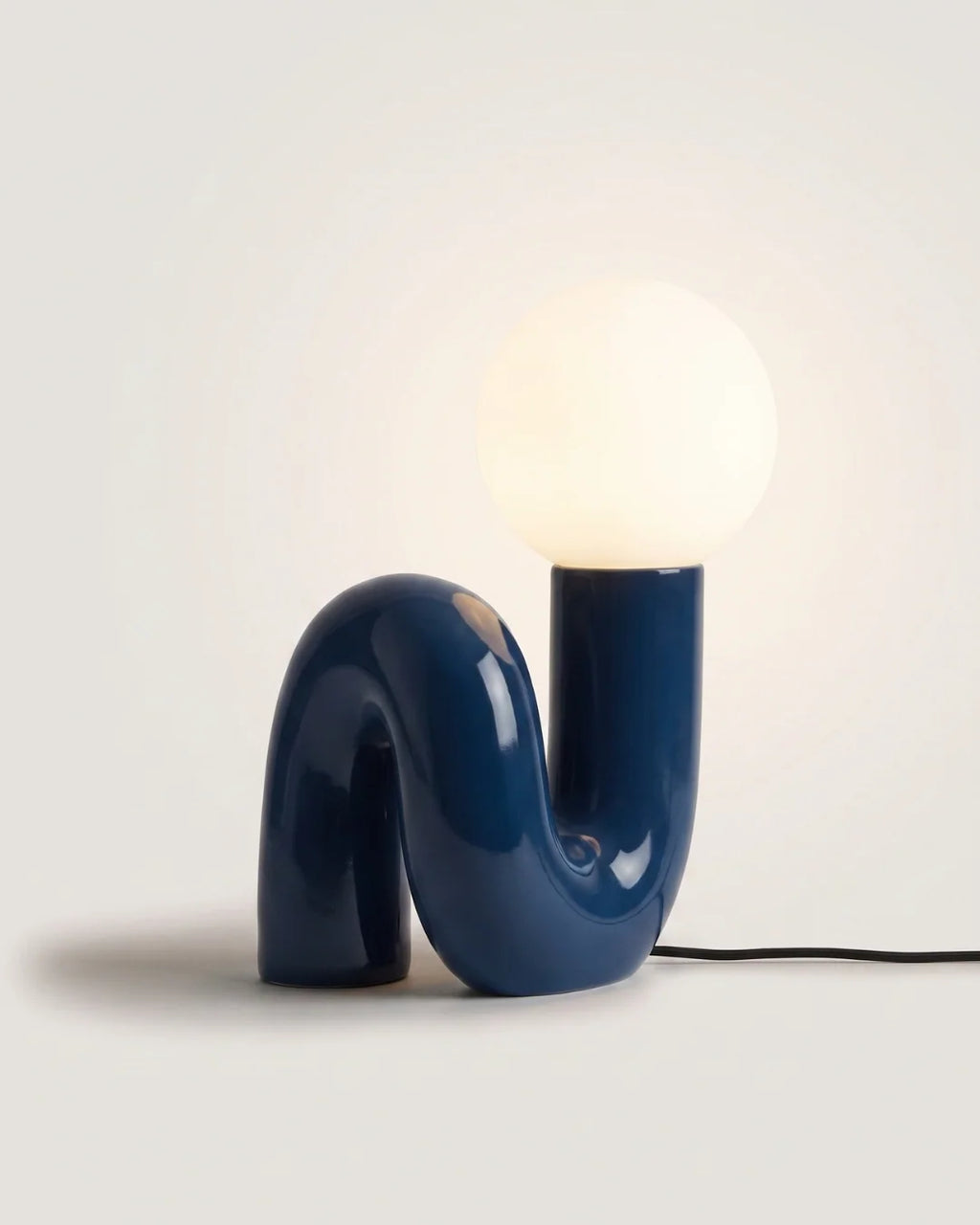 Blue sculptural table lamp with glass globe