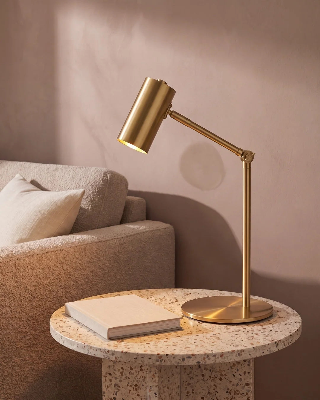Brass desk lamp on side table by sofa