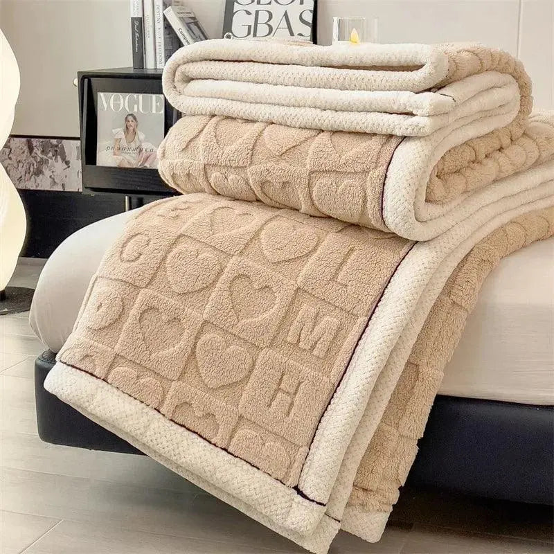 Camel heart embossed fleece blanket folded on bed