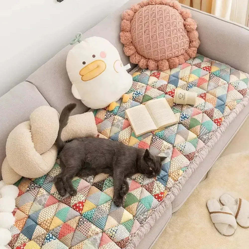 Cat sleeping on quilted pet couch cover