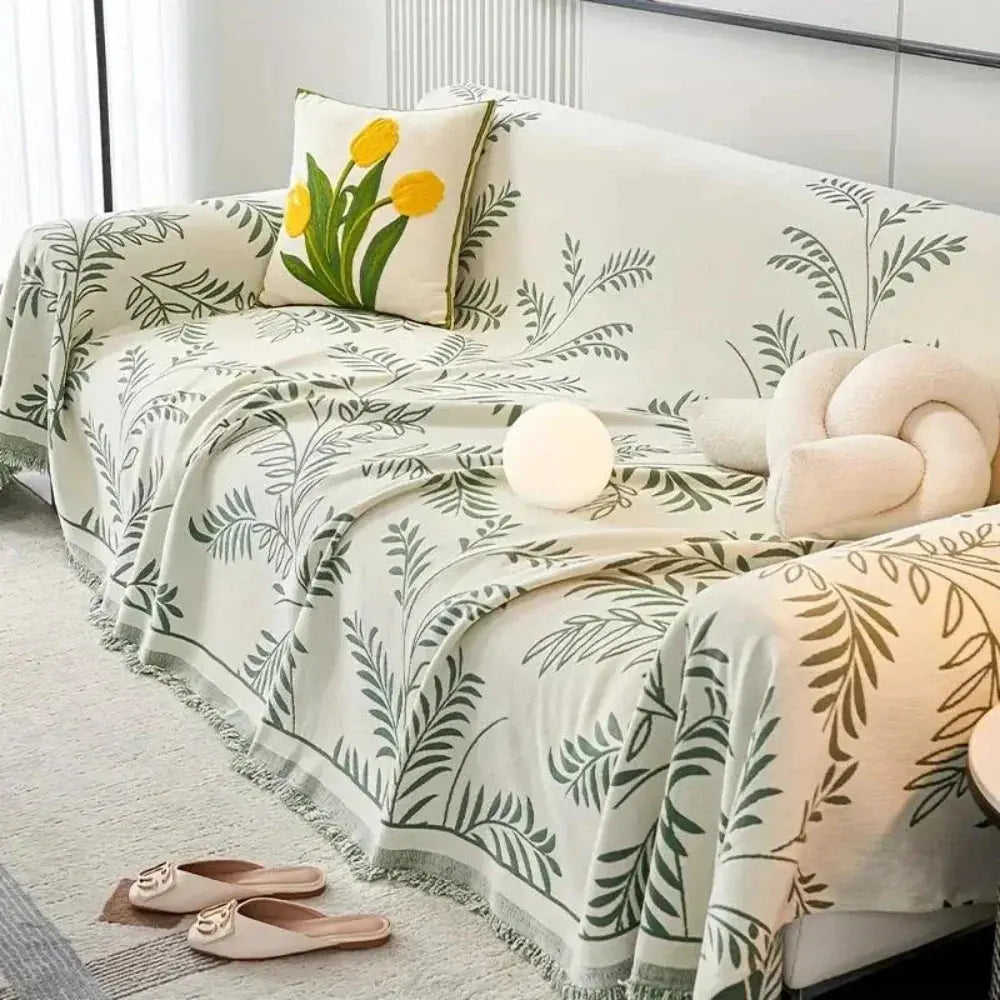 Cream and green leaf couch cover draped over sofa