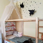 Cream canopy over toddler bed