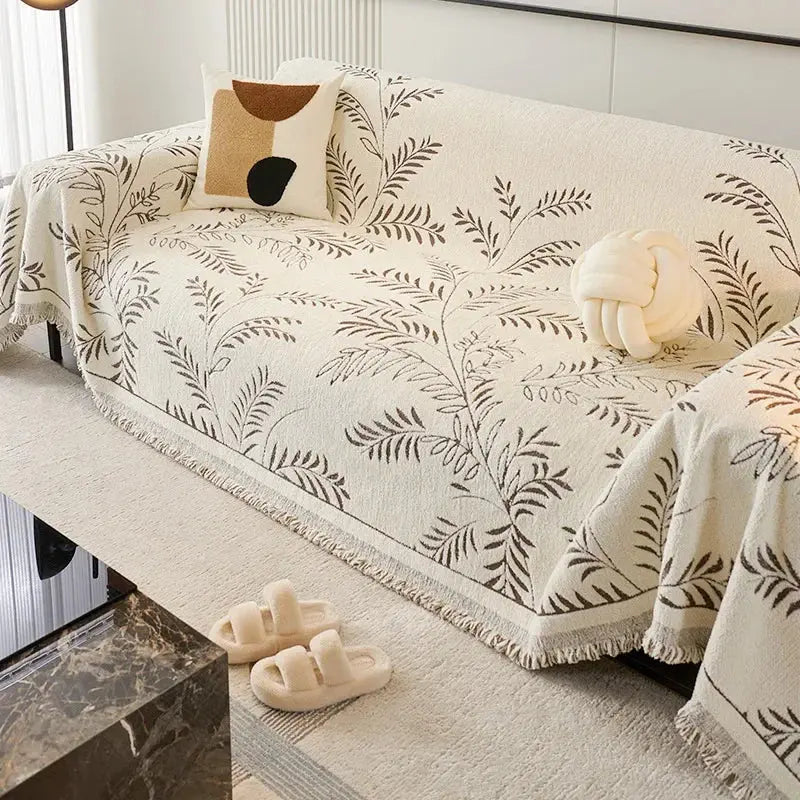 Cream chenille couch cover with green leaf jacquard pattern