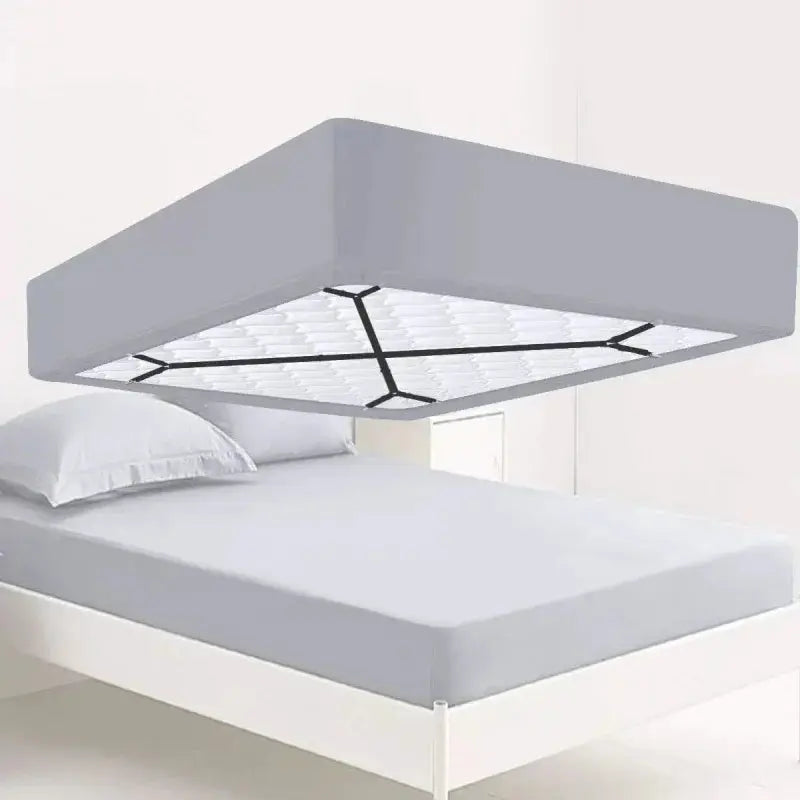 Crisscross straps holding fitted sheet under mattress