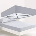 Crisscross straps holding fitted sheet under mattress