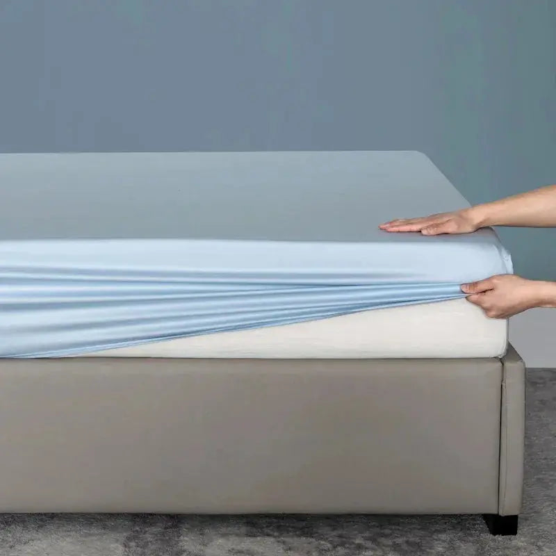 Fitting light blue bamboo sheet on mattress