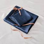 Folded navy satin sheet set with ribbon