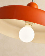 Globe bulb under orange disc shade