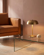 Gold lamp on glass coffee table