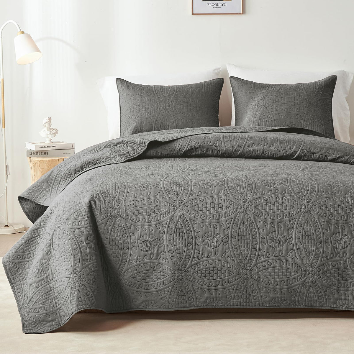 Gray embossed quilt set on bed