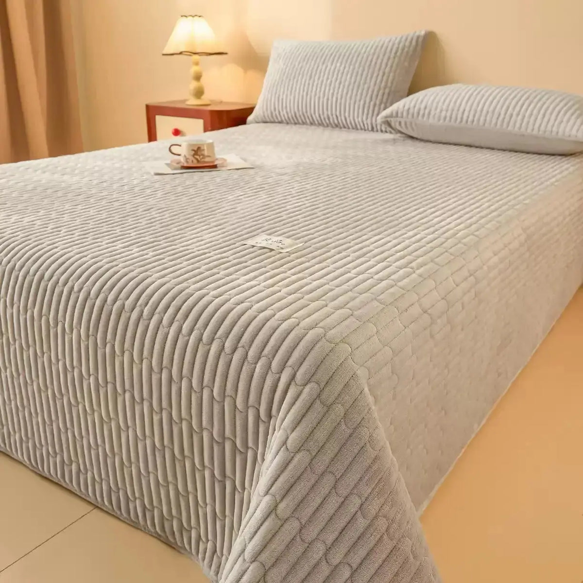 Gray quilted coverlet set on bed