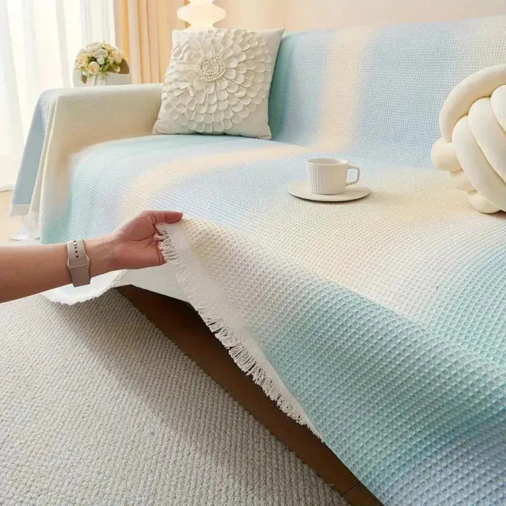 Hand smoothing striped waffle couch cover with fringe