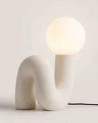 Ivory white sculptural table lamp with glass globe