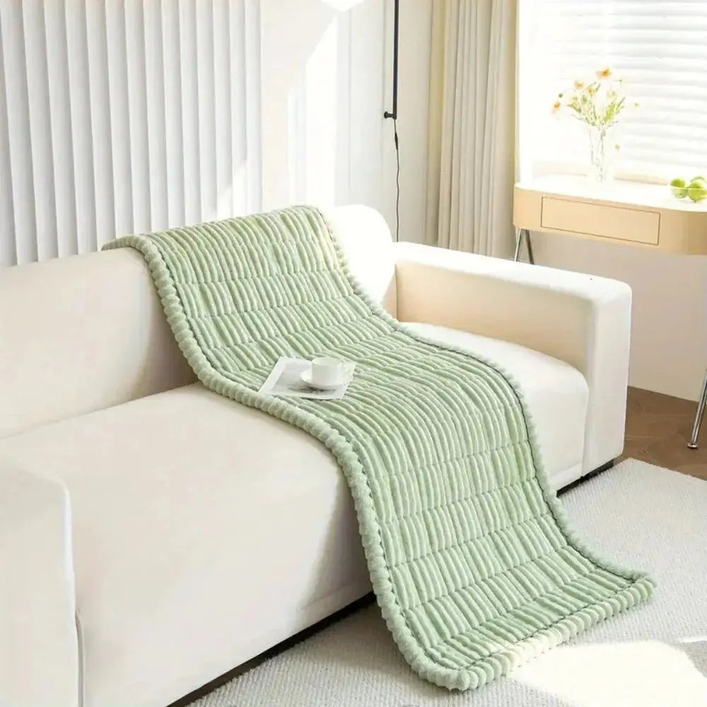 Mint green plush couch cover draped over sofa arm