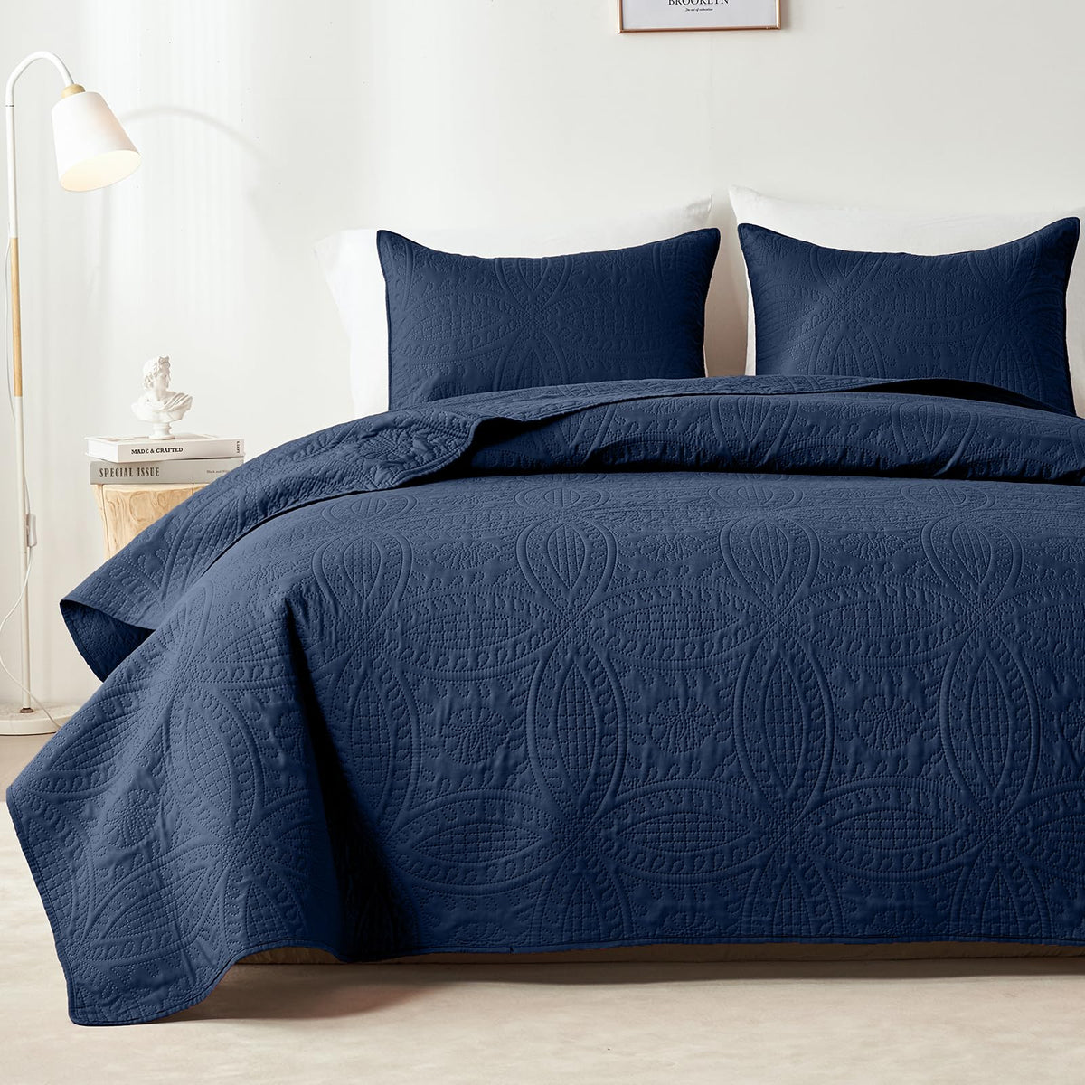 Navy blue embossed quilt set on bed