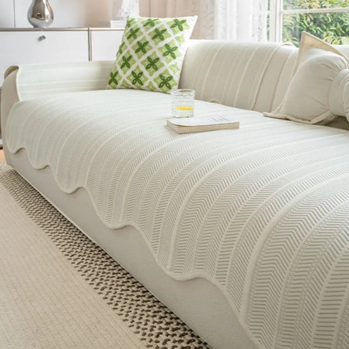 Cream non-slip couch cover with scalloped edge on sectional sofa