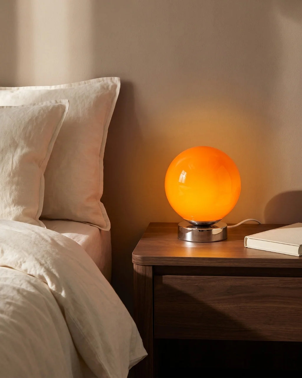 Orange globe lamp on nightstand