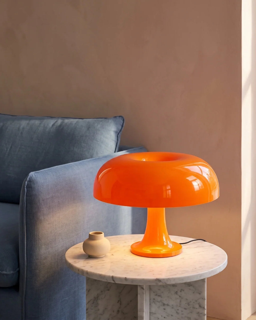 Orange mushroom lamp by sofa