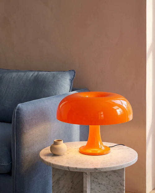 Orange mushroom lamp by sofa