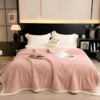 Pink embossed fleece blanket on bed