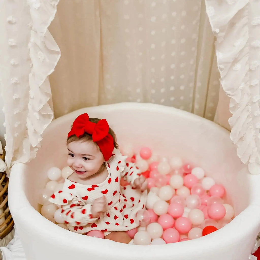 Ruffled canopy over baby ball pit