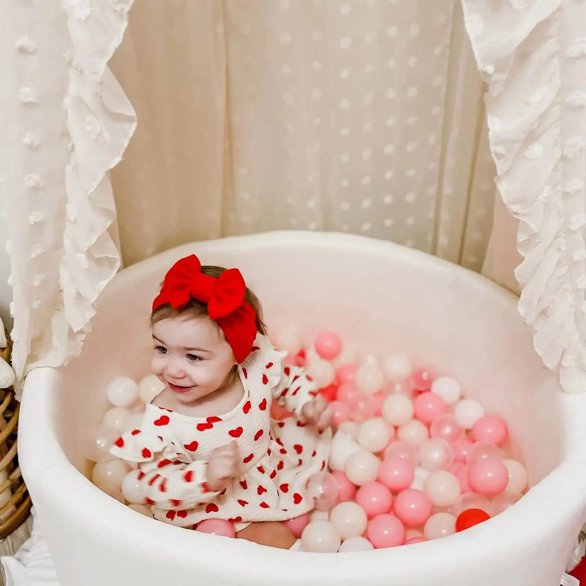 Ruffled canopy over baby ball pit