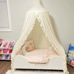 Ruffled cream canopy over kids bed