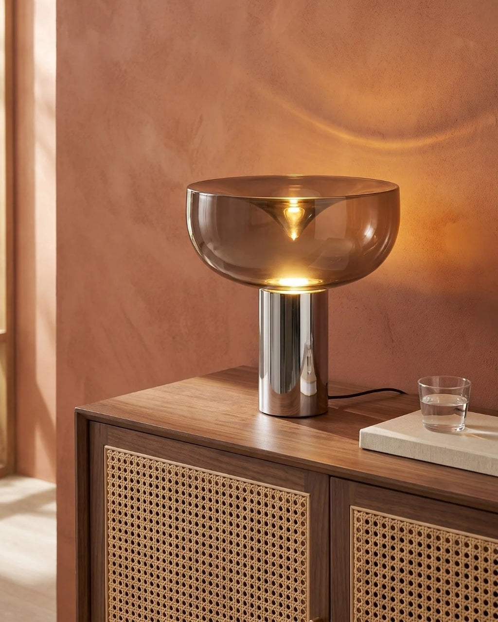 Smoked glass lamp on rattan sideboard