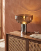 Smoked glass lamp on rattan sideboard