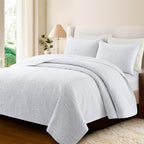 White embossed quilt set on bed