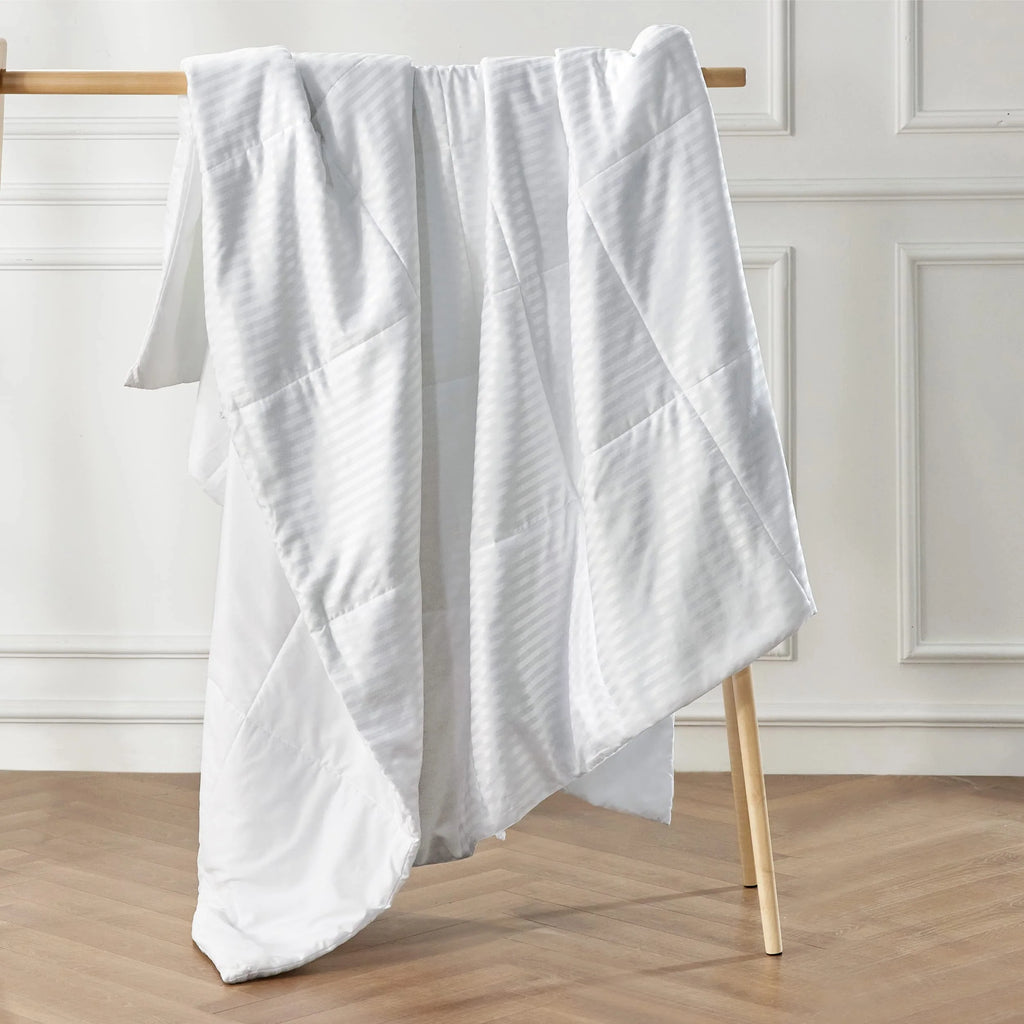 White summer comforter folded over chair