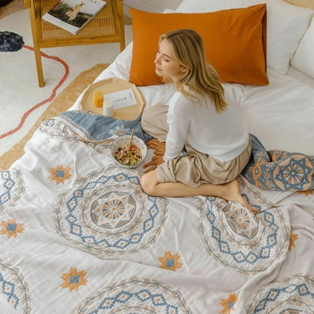 Woman relaxing on boho gauze bedspread