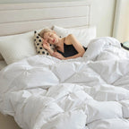 Woman relaxing under fluffy goose down comforter