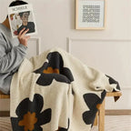 Woman with floral fleece throw on chair